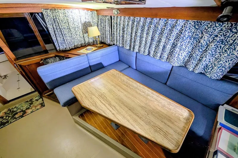 Slide: The Image of Interior of 1986 Bayliner 3270 Motoryacht with blue seating and wooden table. - 17
