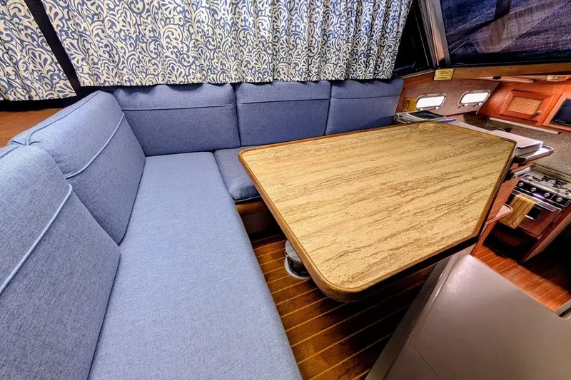 Slide: The Image of Interior of 1986 Bayliner 3270 Motoryacht with blue seating and wooden table. - 18
