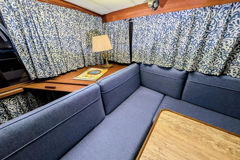 Slide: The Image of Interior of 1986 Bayliner 3270 Motoryacht with blue seating and patterned curtains. - 19