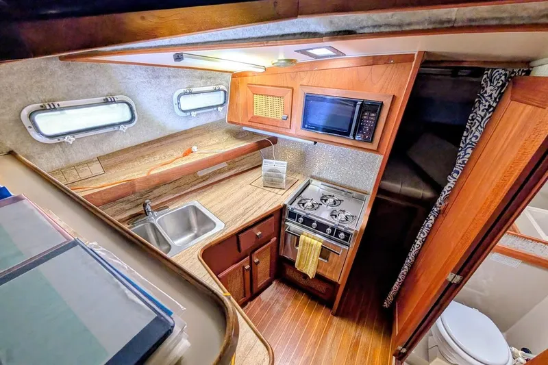 Slide: The Image of 1986 Bayliner 3270 Motoryacht interior kitchen with stove, sink, and microwave. - 20
