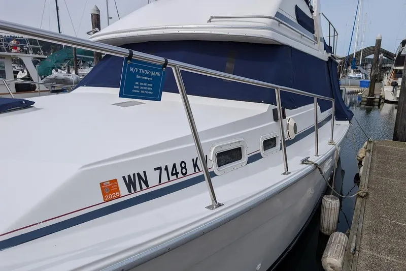 Slide: The Image of 1986 Bayliner 3270 Motoryacht docked at marina, featuring registration number WN 7148 K. - 4