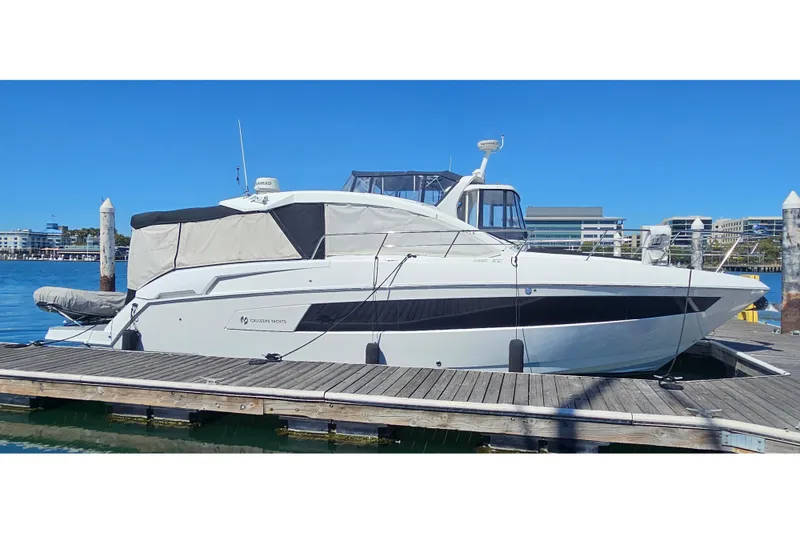 The Image of 2017 Cruisers Yachts 390 Express Coupe docked at marina under clear blue sky. - 0
