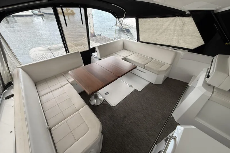 Slide: The Image of 2017 Cruisers Yachts 390 Express Coupe interior with seating and wooden table. - 11