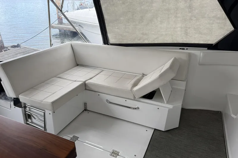 Slide: The Image of 2017 Cruisers Yachts 390 Express Coupe interior with white cushioned seating. - 14