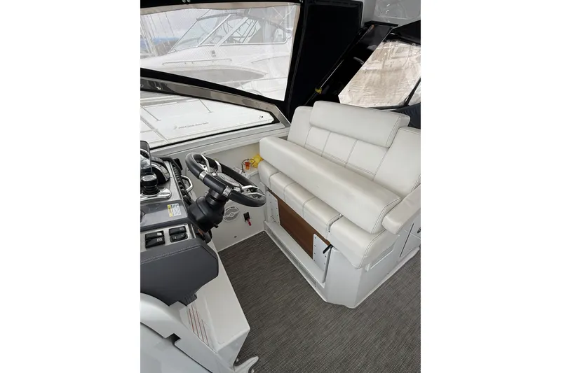 Slide: The Image of 2017 Cruisers Yachts 390 Express Coupe interior with steering wheel and white seating. - 19