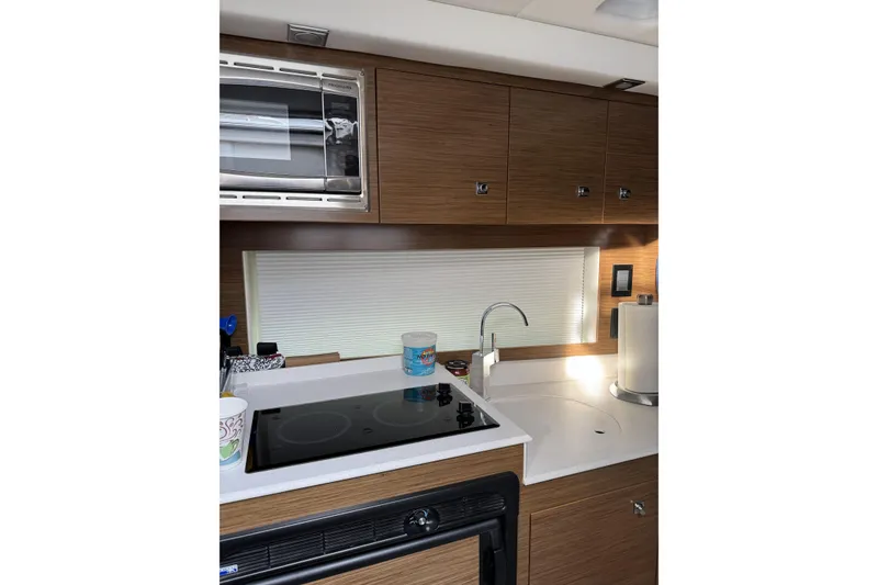 Slide: The Image of Modern kitchen area in 2017 Cruisers Yachts 390 Express Coupe with stove and microwave. - 23