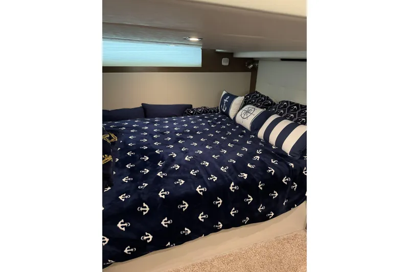 Slide: The Image of Cozy cabin bed in 2017 Cruisers Yachts 390 Express Coupe with nautical-themed bedding. - 26