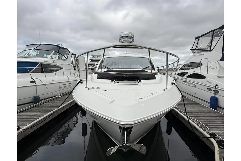 Slide: The Image of 2017 Cruisers Yachts 390 Express Coupe docked between other boats on a cloudy day. - 5