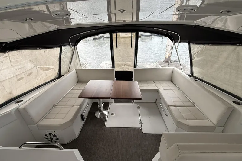 Slide: The Image of 2017 Cruisers Yachts 390 Express Coupe interior with seating and table, dockside view. - 9