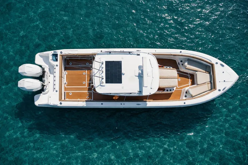Slide: The Image of 2024 Everglades 315 Center Console boat on clear blue water, aerial view. - 10