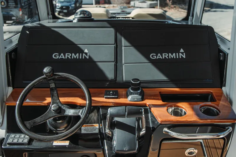 Slide: The Image of 2024 Everglades 315 Center Console helm with Garmin displays and wooden accents. - 37