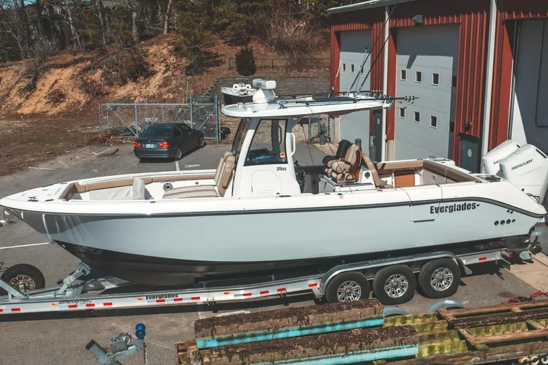Slide: The Image of 2024 Everglades 315 Center Console boat on trailer, parked near a garage. - 4