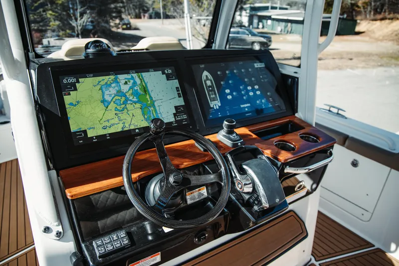 Slide: The Image of 2024 Everglades 315 Center Console dashboard with dual navigation screens and steering wheel. - 43