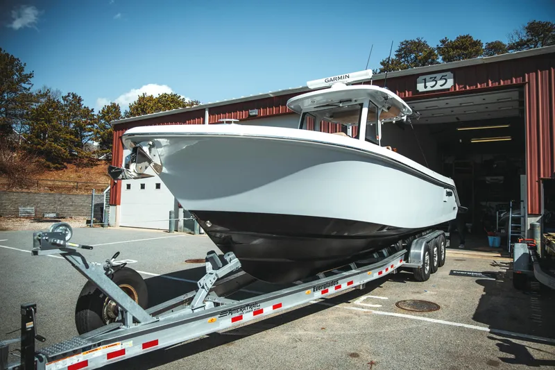 Slide: The Image of 2024 Everglades 315 Center Console boat on trailer outside a garage. - 5