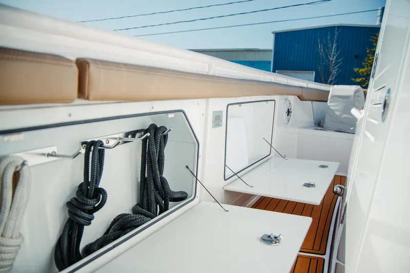 Slide: The Image of 2024 Everglades 315 Center Console boat interior with storage compartments and ropes. - 59