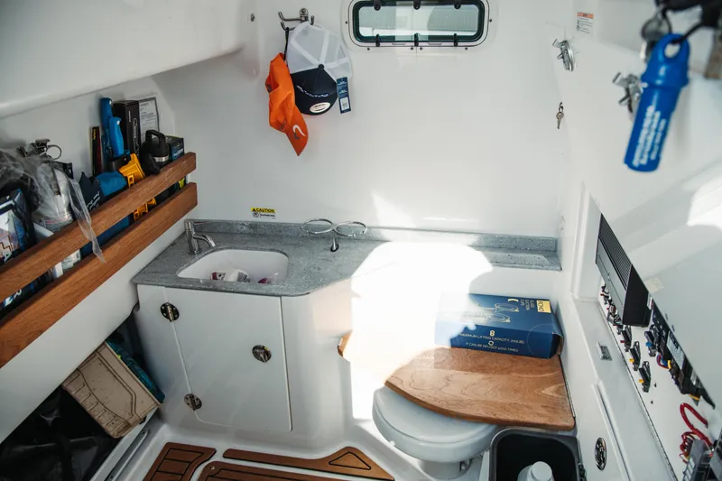 Slide: The Image of 2024 Everglades 315 Center Console cabin with sink, storage, and wooden accents. - 62