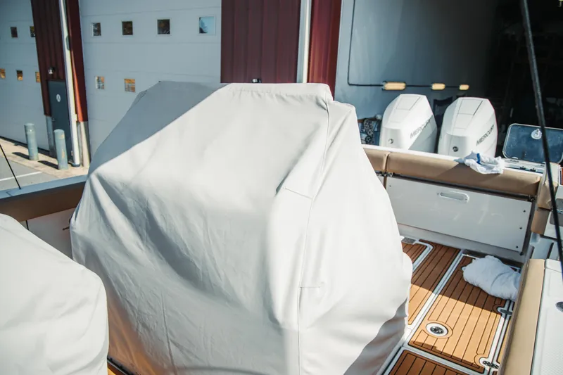 Slide: The Image of 2024 Everglades 315 Center Console boat interior with covered seating and twin Mercury engines. - 69