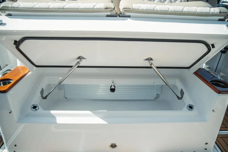 Slide: The Image of 2024 Everglades 315 Center Console storage compartment with open lid and hydraulic supports. - 81