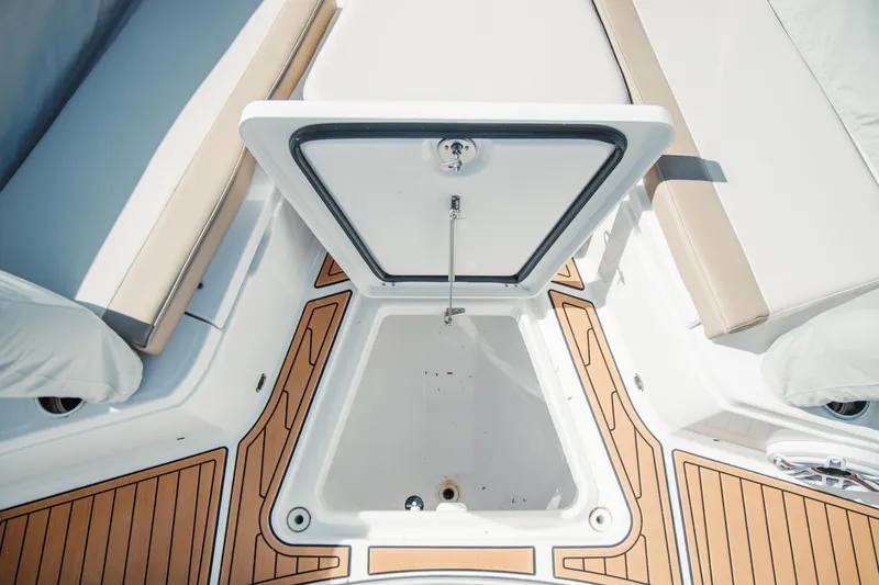 Slide: The Image of 2024 Everglades 315 Center Console boat storage compartment with teak flooring. - 84