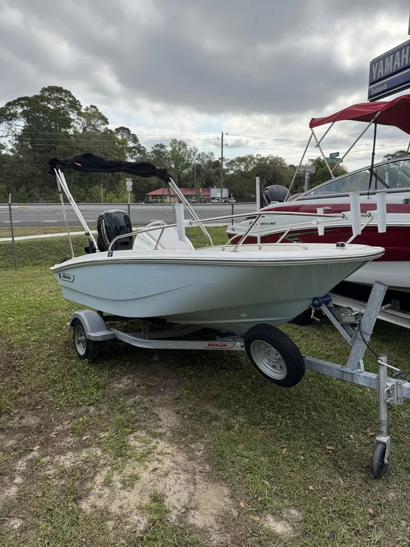 Slide: The Image of 2024 Boston Whaler 130 Super Sport on trailer, parked outdoors. - 2