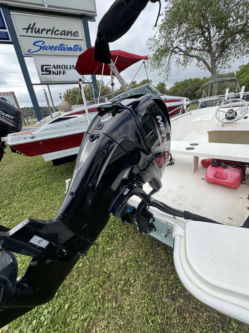 Slide: The Image of 2024 Boston Whaler 130 Super Sport with outboard motor on grass. - 3