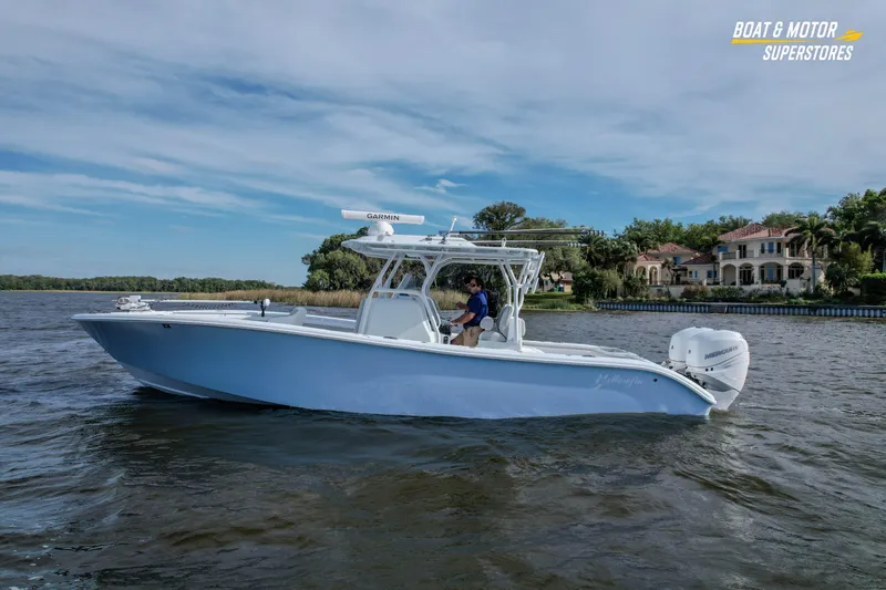 Slide: The Image of 2020 Yellowfin 32 Offshore boat cruising on a scenic waterway near luxury homes. - 2
