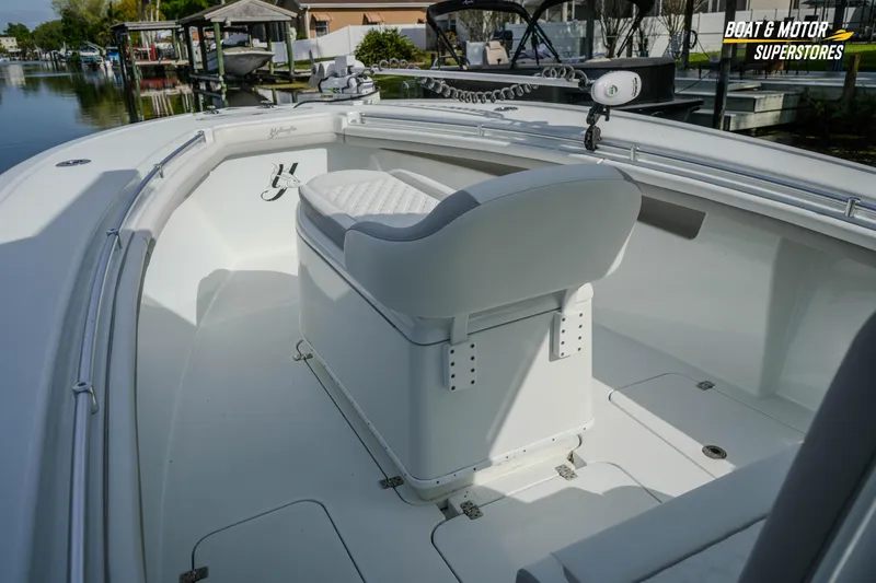 Slide: The Image of 2020 Yellowfin 32 Offshore boat interior with seating, docked near waterfront homes. - 23