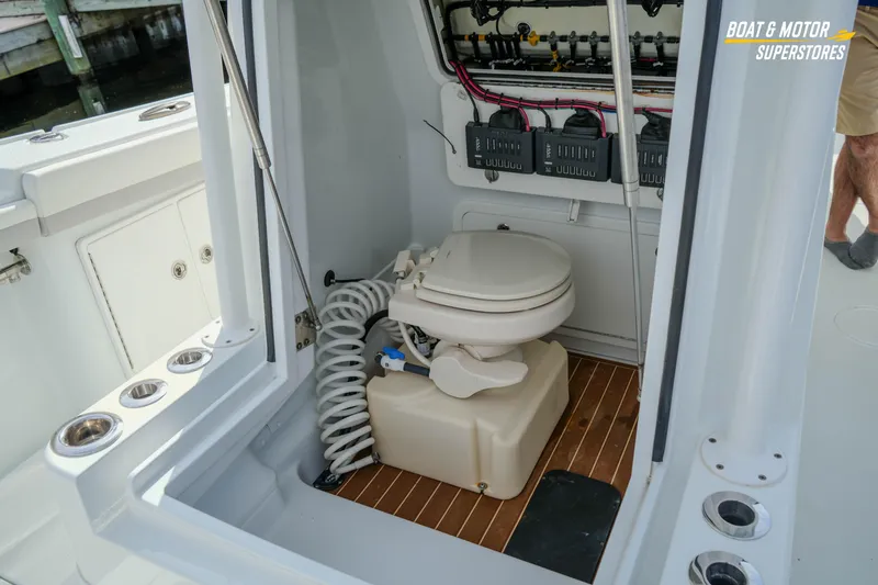Slide: The Image of 2020 Yellowfin 32 Offshore boat interior with marine toilet and electrical panel. - 39