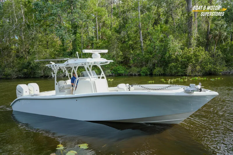 Slide: The Image of 2020 Yellowfin 32 Offshore boat cruising on a serene river with lush greenery. - 51