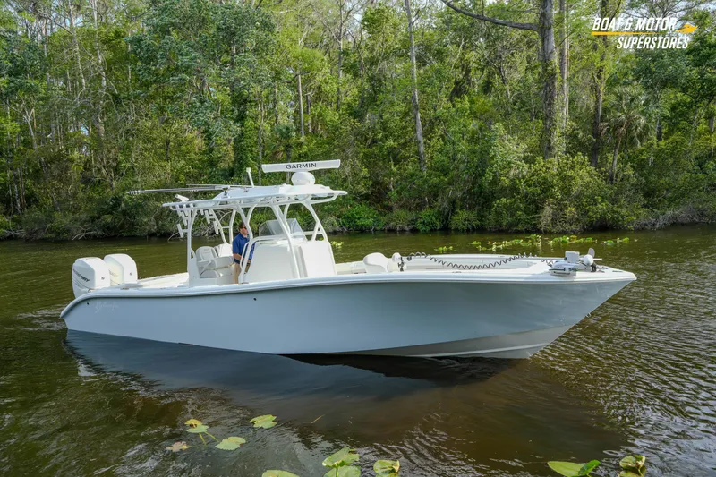 Slide: The Image of 2020 Yellowfin 32 Offshore boat cruising on a serene river surrounded by lush greenery. - 53