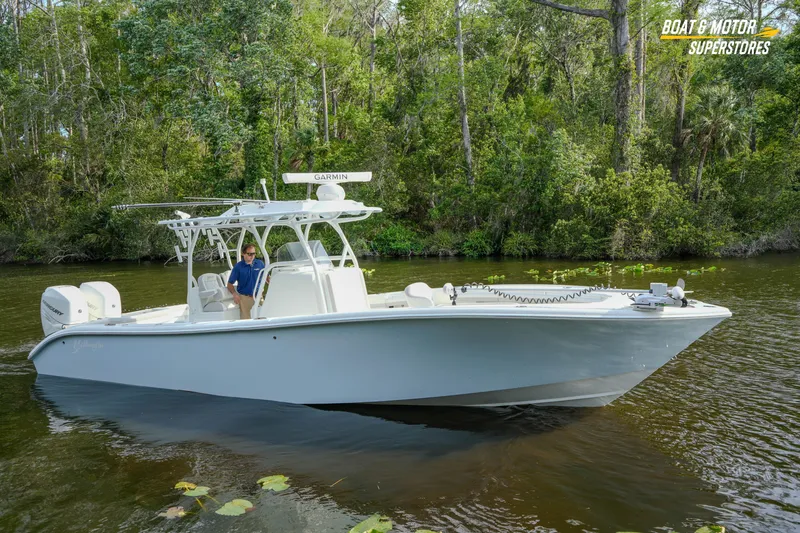 Slide: The Image of 2020 Yellowfin 32 Offshore boat cruising on a serene river with lush greenery. - 54
