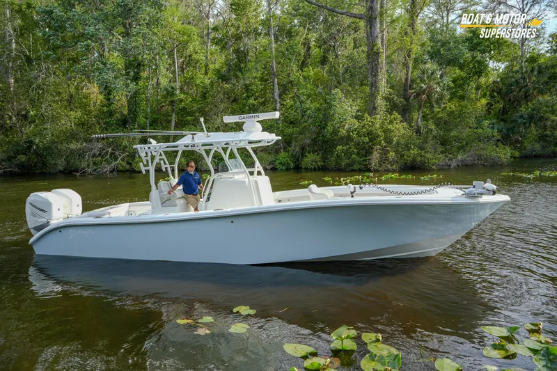 Slide: The Image of 2020 Yellowfin 32 Offshore boat cruising on a scenic river with lush greenery. - 55