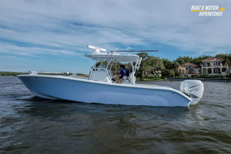 Slide: The Image of 2020 Yellowfin 32 Offshore boat cruising on a scenic waterway near luxury homes. - 58