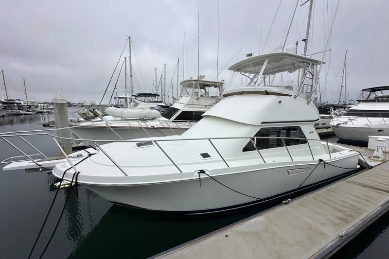 The Image of 2002 Skipjack 36 Flybridge yacht docked at marina, overcast sky. - 0