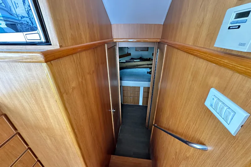 Slide: The Image of Interior view of 2002 Skipjack 36 Flybridge, featuring wooden paneling and a cozy cabin. - 10