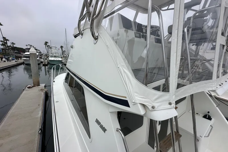 Slide: The Image of Skipjack 36 Flybridge 2002 docked at marina, showcasing sleek design and flybridge enclosure. - 14