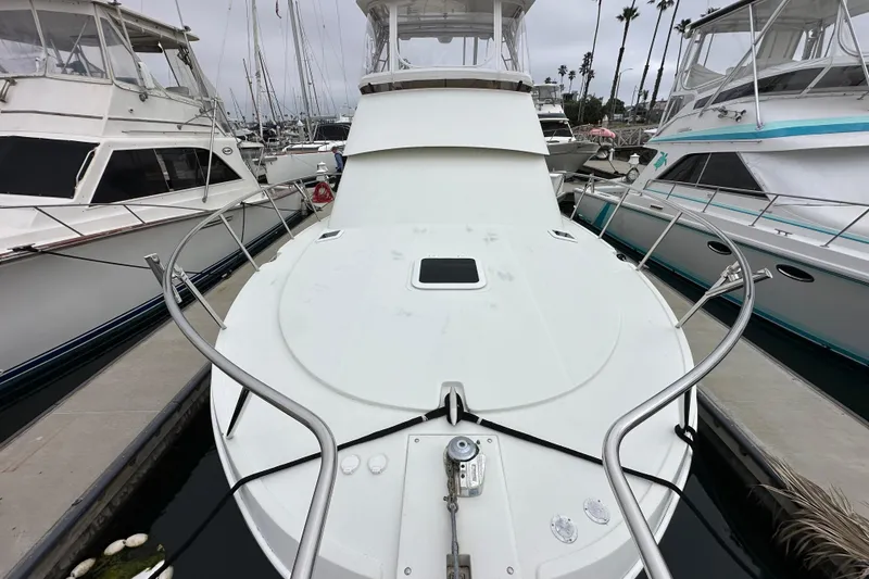 Slide: The Image of 2002 Skipjack 36 Flybridge yacht docked at marina, surrounded by other boats. - 4