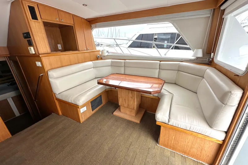 Slide: The Image of Interior of 2002 Skipjack 36 Flybridge with beige seating and wooden table. - 9