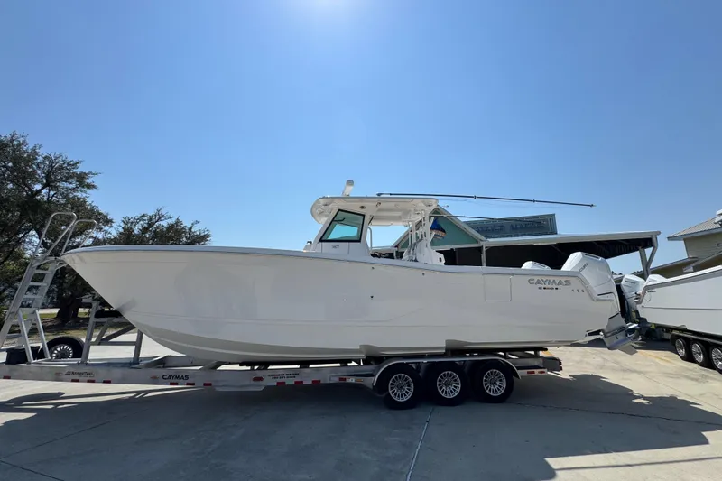 The Image of 2025 Caymas 34 CT boat on trailer under clear blue sky. - 1