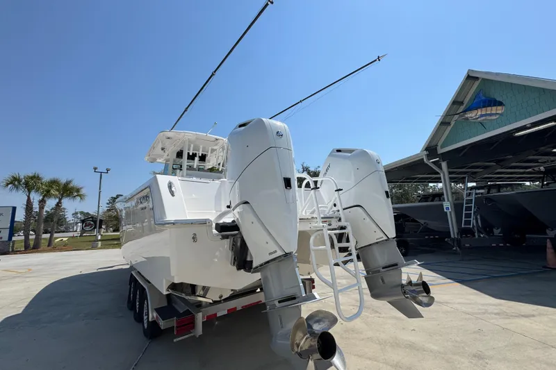 Slide: The Image of 2025 Caymas 34 CT boat with dual outboard motors in a sunny marina setting. - 16