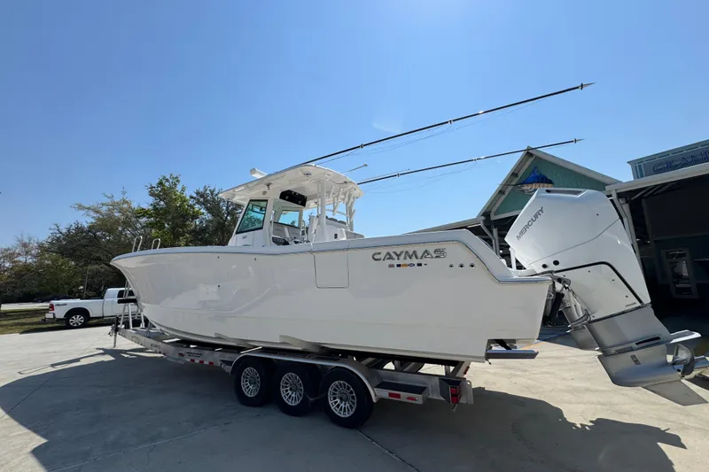 Slide: The Image of 2025 Caymas 34 CT boat on trailer, parked outdoors under clear blue sky. - 18