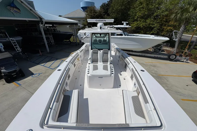 Slide: The Image of 2025 Caymas 34 CT boat with spacious deck and modern design in a marina setting. - 23