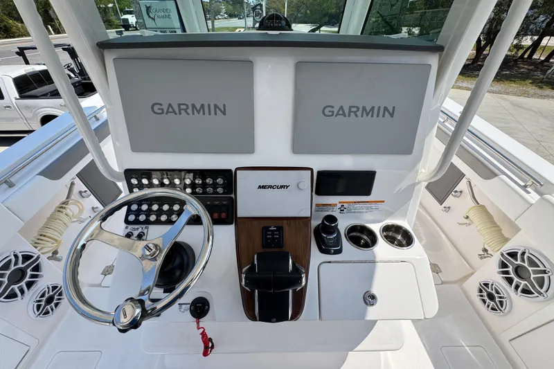 Slide: The Image of Helm of 2025 Caymas 34 CT boat featuring dual Garmin displays and Mercury controls. - 34