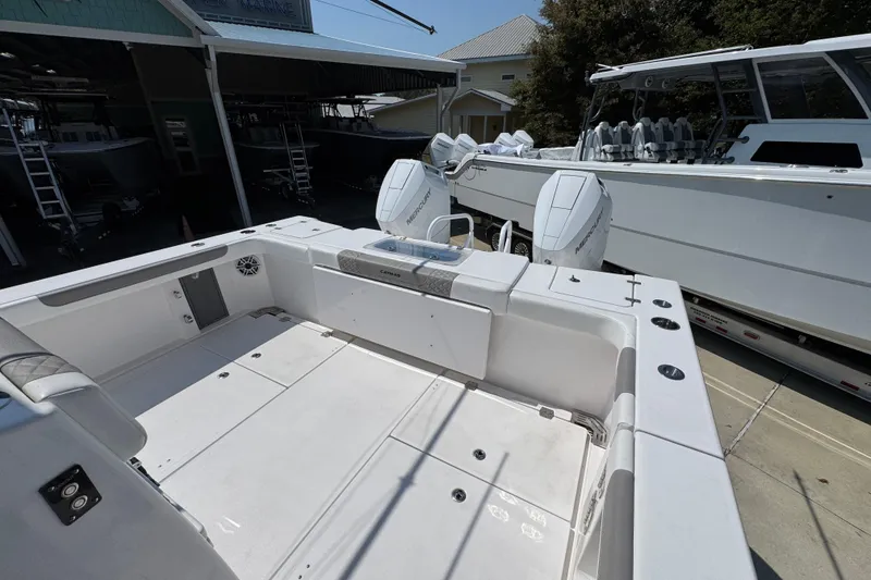 Slide: The Image of 2025 Caymas 34 CT boat with dual Mercury engines, docked at a marina. - 41