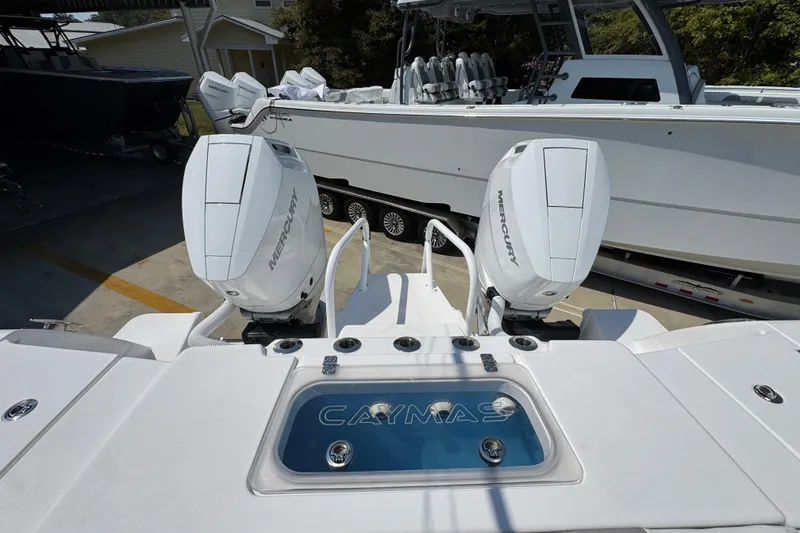 Slide: The Image of 2025 Caymas 34 CT boat with dual Mercury engines, docked outdoors. - 44