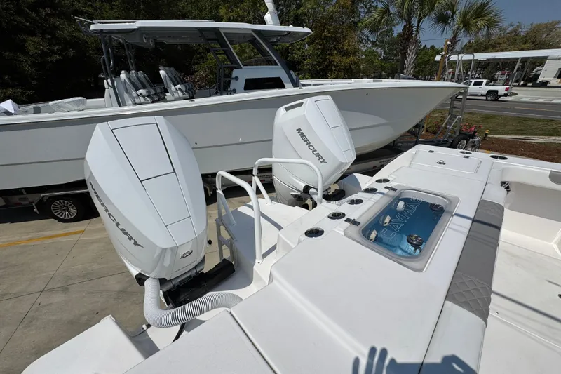 Slide: The Image of 2025 Caymas 34 CT boat with dual Mercury engines, docked outdoors. - 46