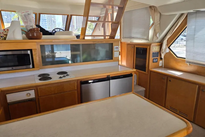 Slide: The Image of Interior of 1994 Navigator 5600 yacht kitchen with appliances and wooden cabinetry. - 16