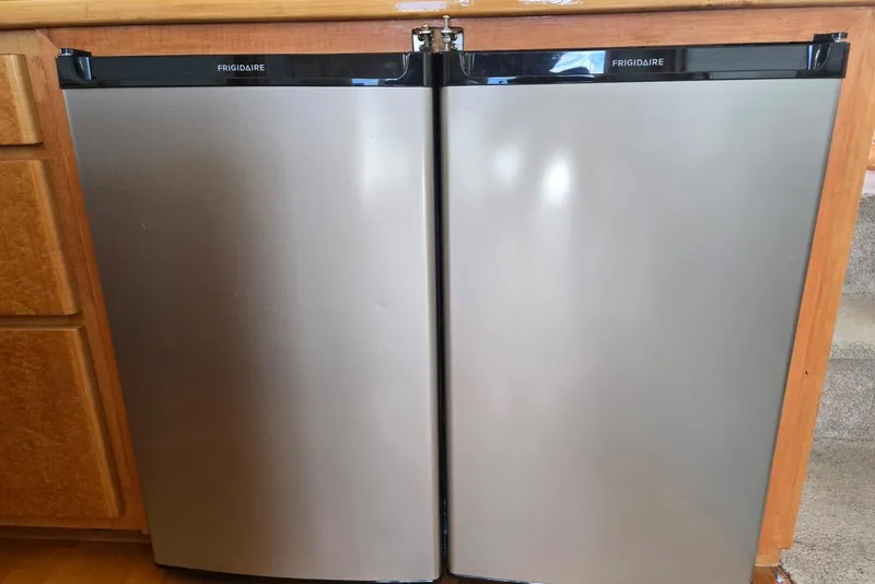 Slide: The Image of Stainless steel Frigidaire mini fridge with double doors in a wooden kitchen setting. - 21