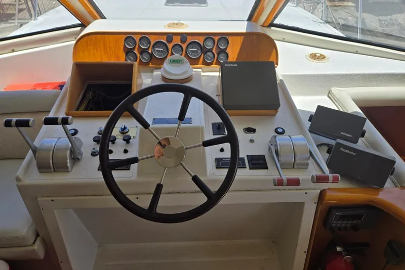 Slide: The Image of 1994 Navigator 5600 yacht helm with steering wheel, controls, and navigation equipment. - 23