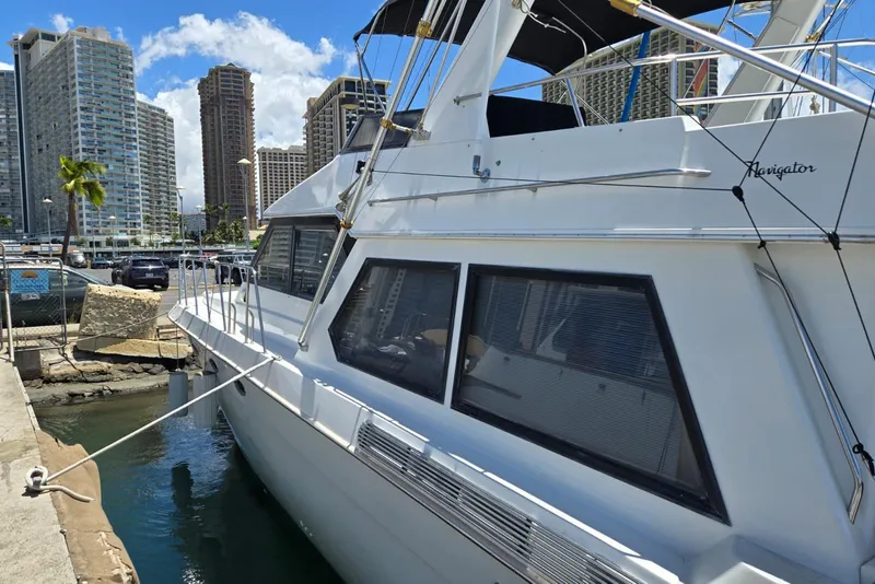 Slide: The Image of 1994 Navigator 5600 yacht docked in urban marina with skyscrapers in background. - 4